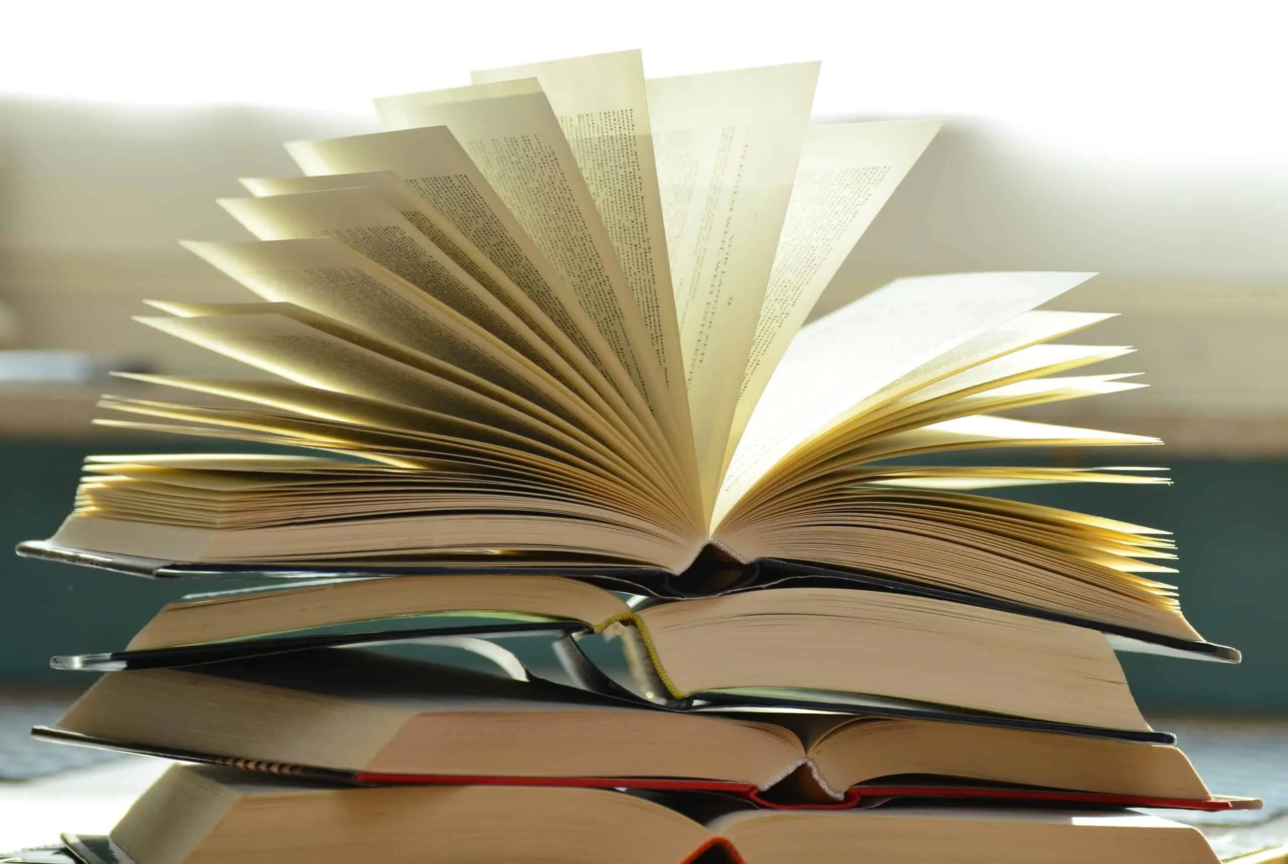 Open hardcover books stacked on a table