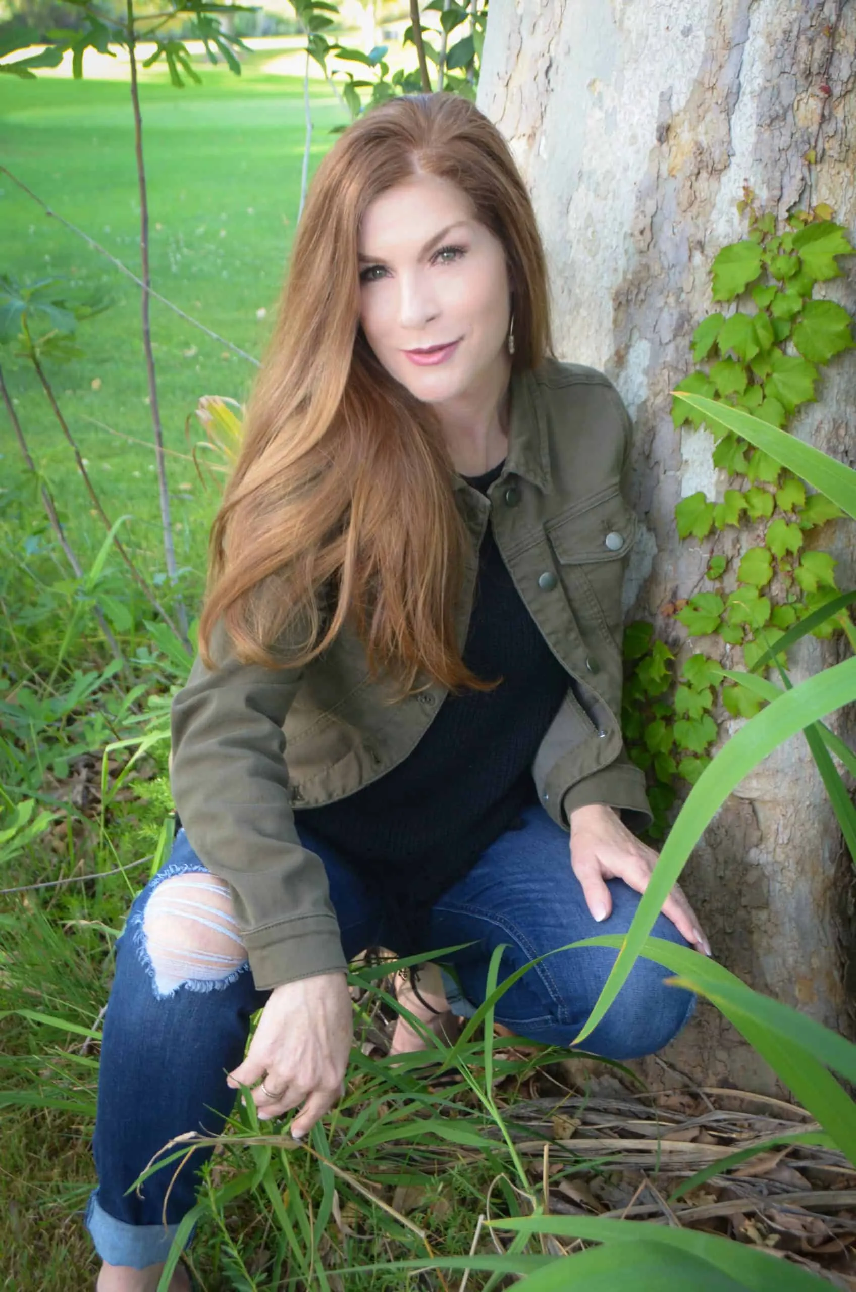 Dr. Tammy Bradshaw-Scott outdoors beside a tree, in a casual jacket and jeans