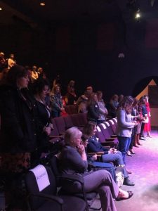 Responsive Alt Text: Women praying during event at conference or seminar.